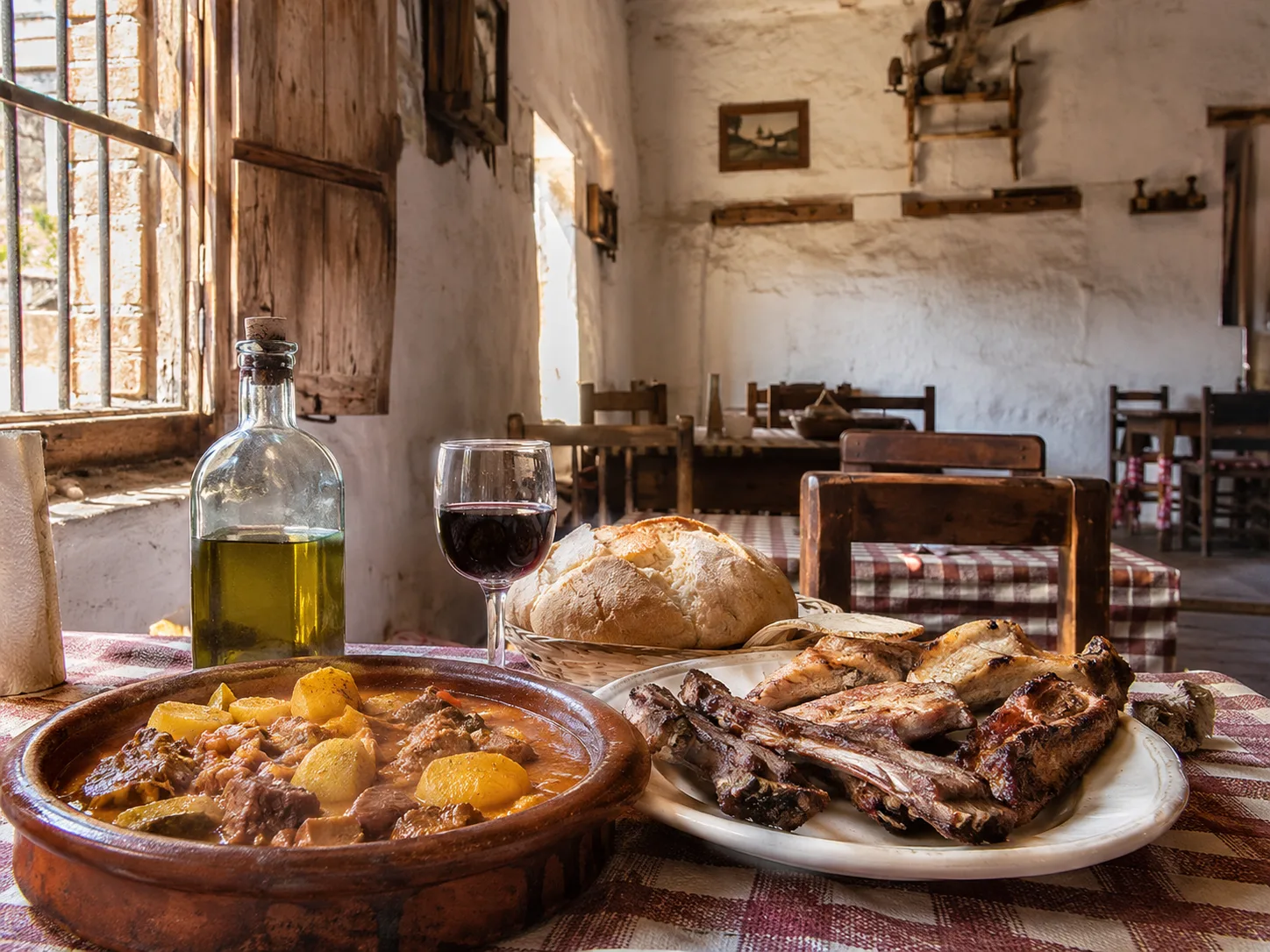Interior de una venta tradicional en Coín con carnes a la brasa y guiso malagueño sobre mesa de madera